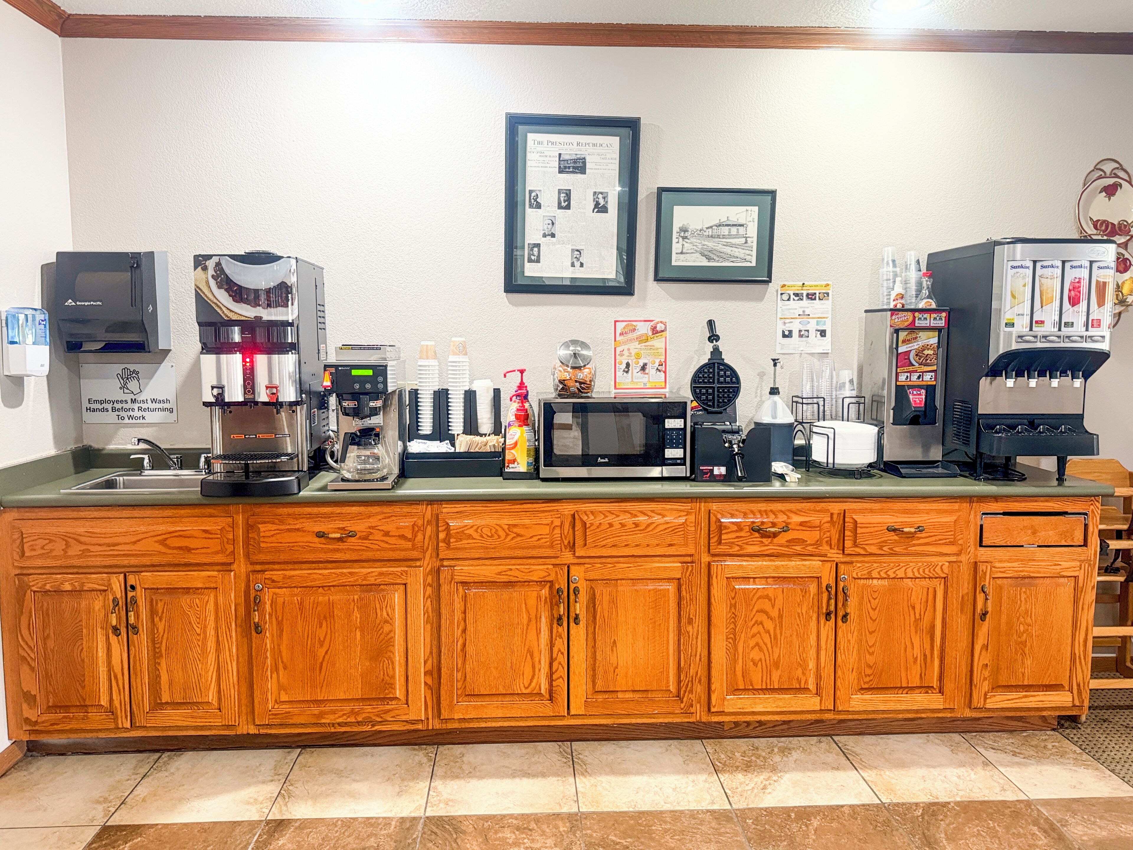 A coffee station with a coffee machine, microwave, and various coffee dispensers.