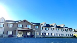 A multi-story hotel with a covered entrance and outdoor seating area.