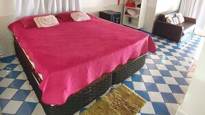A room with a bed, a wardrobe, a small table, and a sofa. - Aconchego do Caranã (Salinópolis)