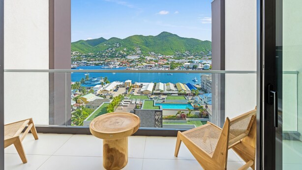 A balcony with a view of a marina and mountains. - B254 - Cozy Apartment in the Heart of Simpson Bay (Sint Maarten)