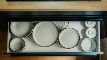 A drawer with various plates and bowls, indicating a kitchen area.