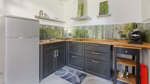 Una cocina moderna con refrigerador, encimera de madera y armarios empotrados.
