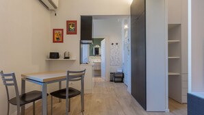 Uma cozinha compacta com área de refeições, forno embutido e micro-ondas.