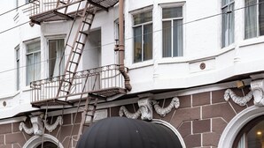 A hotel entrance with a black awning, brick facade, and a fire escape. - Hotel Julian (San Francisco)