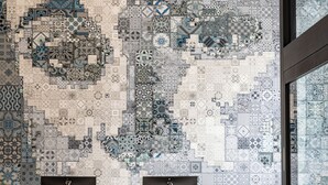 A reception area with a mosaic wall, a blue counter, and a tiled floor. - Hotel Julian (San Francisco)