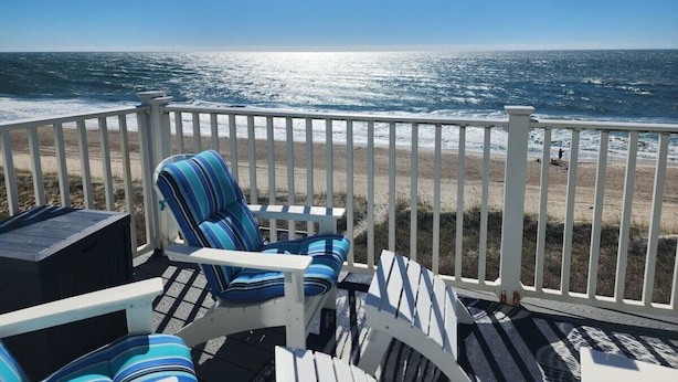 A deck with a view of the ocean, featuring a chair and a small table. - MillionDollarView-Oceanfront 1BR-Updated! (Salter Path)