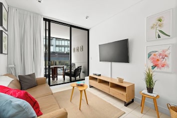 This modern apartment features streamlined interiors with an open plan design that flows to the balcony.