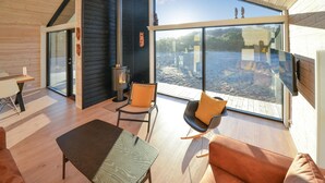 A modern interior with a large glass window, a fireplace, and a wooden floor. - 3 bedroom lovely home in Anholt (Anholt)