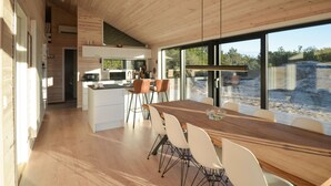 A modern kitchen with white cabinets, a wooden countertop, and a large window overlooking a construction site. - 3 bedroom lovely home in Anholt (Anholt)