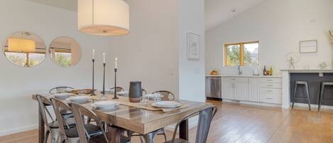 Un comedor con una mesa de madera, sillas de metal y una lámpara colgante.
