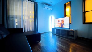 Un salon moderne avec un canapé, un téléviseur à écran plat et un plancher en bois.