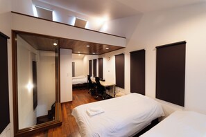 A hotel room with a large mirror, a desk, two beds, and a wooden floor. - Satellite Hotel Roppongi (Tokyo)