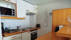 A compact kitchen with white cabinets, a microwave, a kettle, and a sink. - Beautiful  flat with air conditioning, swimming pool and parking - 6REFC5 (SAINT CYPRIEN PLAGE)