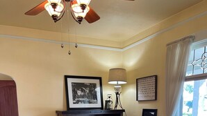 Un comedor con una mesa de madera, sillas, una araña, chimenea y vistas al exterior.