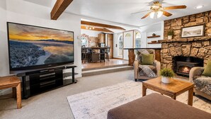Ein Wohnzimmer mit Fernseher, Kamin und einer Sitzecke.