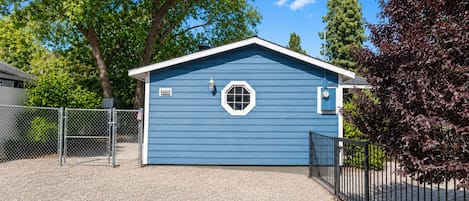 A single-story building with a blue exterior, a white door, and a small window.
