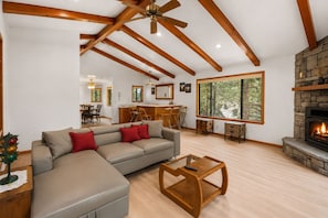 A spacious living room with a fireplace, a dining area, and a kitchen. - Silver Rays - Walk to Lake/Village, Game Room, Pool Table, Air Hockey, BBQ (Big Bear Lake)