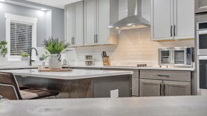 A modern kitchen with grey cabinets, a stainless steel range hood, and a built-in oven. - Beautiful Lake getaway with pool, upgraded, pet friendly with lots of extras!! (Green Cove Springs)