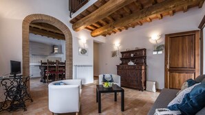 Uma sala de estar com lareira, área de jantar e cozinha.