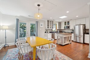 Enjoy meals at the dining table surrounded by comfortable chairs, a refrigerator, and oven.