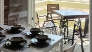 A dining area with a table set for four, chairs, and a view of a garden through a glass door. - 1 bedroom amazing home in Ustronie Morskie (Ustronie Morskie)