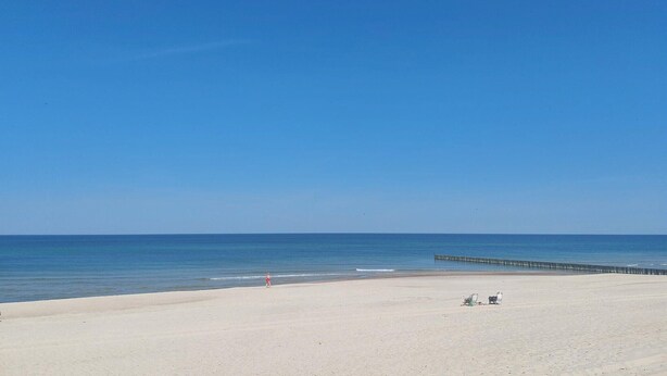 A beach with a clear sky, a sandy shore, and a pier extending into the water. - 1 bedroom amazing home in Ustronie Morskie (Ustronie Morskie)