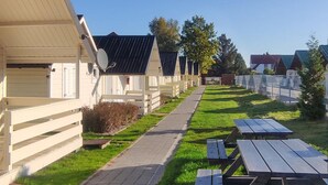 A row of cabins with a paved walkway and picnic tables. - 1 bedroom amazing home in Ustronie Morskie (Ustronie Morskie)