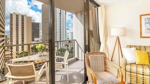 A balcony with a table, chairs, and a sofa.
