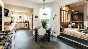 A modern kitchen with a dining area, built-in appliances, and a large window. - Beautiful 3BD Home Forest Hill South London (Greater London)