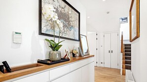 A reception desk with a potted plant, framed picture, and a digital clock.
