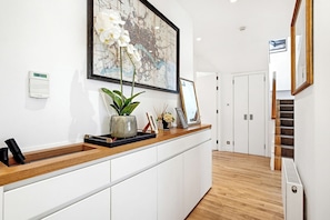 A reception desk with a potted plant, framed picture, and a digital clock.