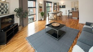 Un salon moderne comprenant un téléviseur, un canapé, une table basse et un coin repas.