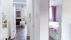 Een slaapkamer met een bed, nachtkastje en een raam met gordijnen.