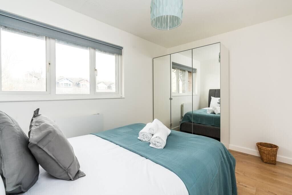 Quarto com cama, espelho grande, janela e vista exterior.