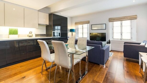 A modern apartment with a kitchen, dining area, and living room. - A Stunning Three Bedroom Home in Mayfair (Greater London)