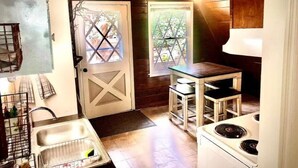 Una cocina compacta con un lavabo, estufa y una pequeña mesa.