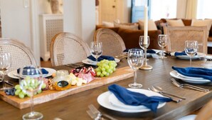 A dining table set with plates, cutlery, and a charcuterie board with various cheeses and grapes. - The Victorian Blue 25min to NYC (Mount Vernon)