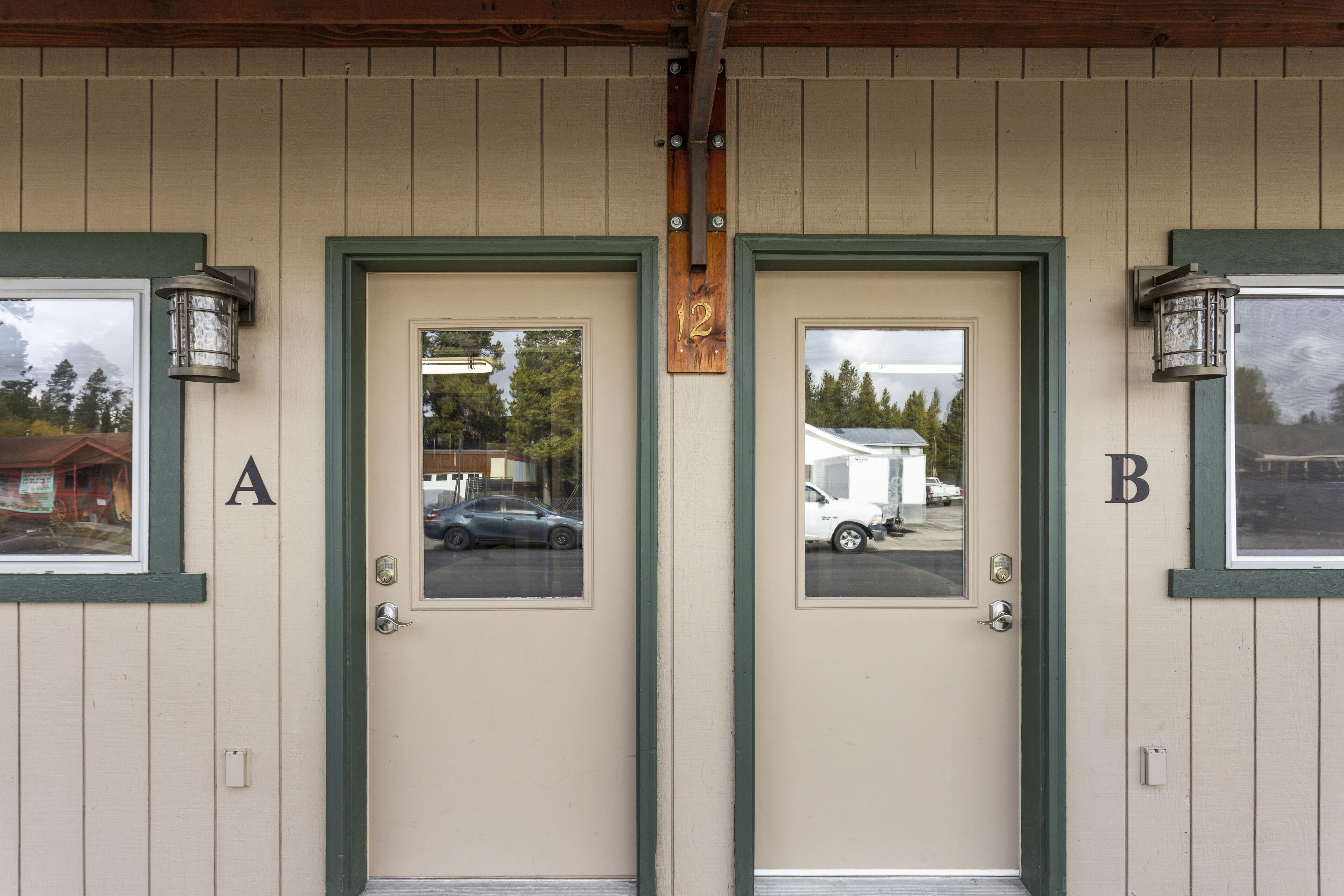 A building facade with two doors labeled A and B, each with a small window and a doorbell above.