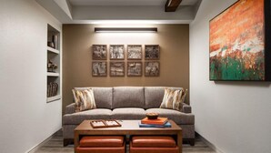 A living room with a grey sofa, a coffee table, and a bookshelf. - Sheraton Lakeside Terrace Villas at Mountain Vista - 2 Bedroom Villa (Avon)