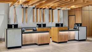 A reception area with wooden reception desks, a modern ceiling design, and a clean, minimalist aesthetic.