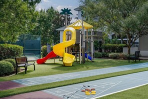 Un parque infantil con un tobogán y una casita de juegos.