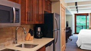 Habitación de hotel con kitchenette, que incluye microondas, refrigerador, pileta y cafetera.