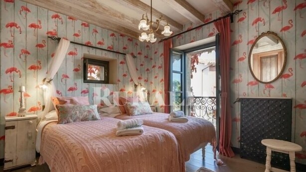 A bedroom with two beds, a large window, and a mirror. - El Jardín Escondido - country house in Helgueras (Cantabria) | 12 guests (Helgueras)