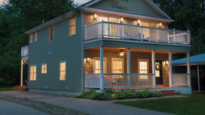 A two-story house with a balcony, large windows, and a porch. - 5 O'clock Somewhere - large home, hot tub & close to the beach! (South Haven)