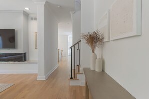 Um interior moderno com uma escada, uma TV de tela plana e decoração minimalista.