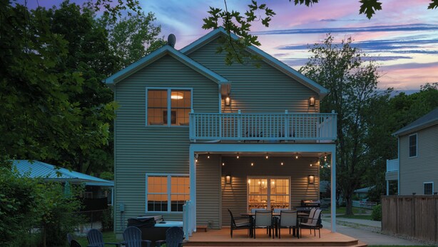 A two-story house with a covered patio, outdoor seating, and a fire pit. - 5 O'clock Somewhere - large home, hot tub & close to the beach! (South Haven)