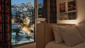 Un dormitorio con un ventanal grande que da a vistas de la ciudad.