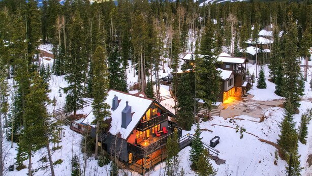 A lodge with a central building and a smaller structure, surrounded by a forest and snow-covered ground. - The Apres Chalet on Peak 7, Private Hot Tub, Locaton & Great Views! (Breckenridge)