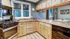 A kitchen with wooden cabinets, a granite countertop, a stove, and a dishwasher. - The Apres Chalet on Peak 7, Private Hot Tub, Locaton & Great Views! (Breckenridge)