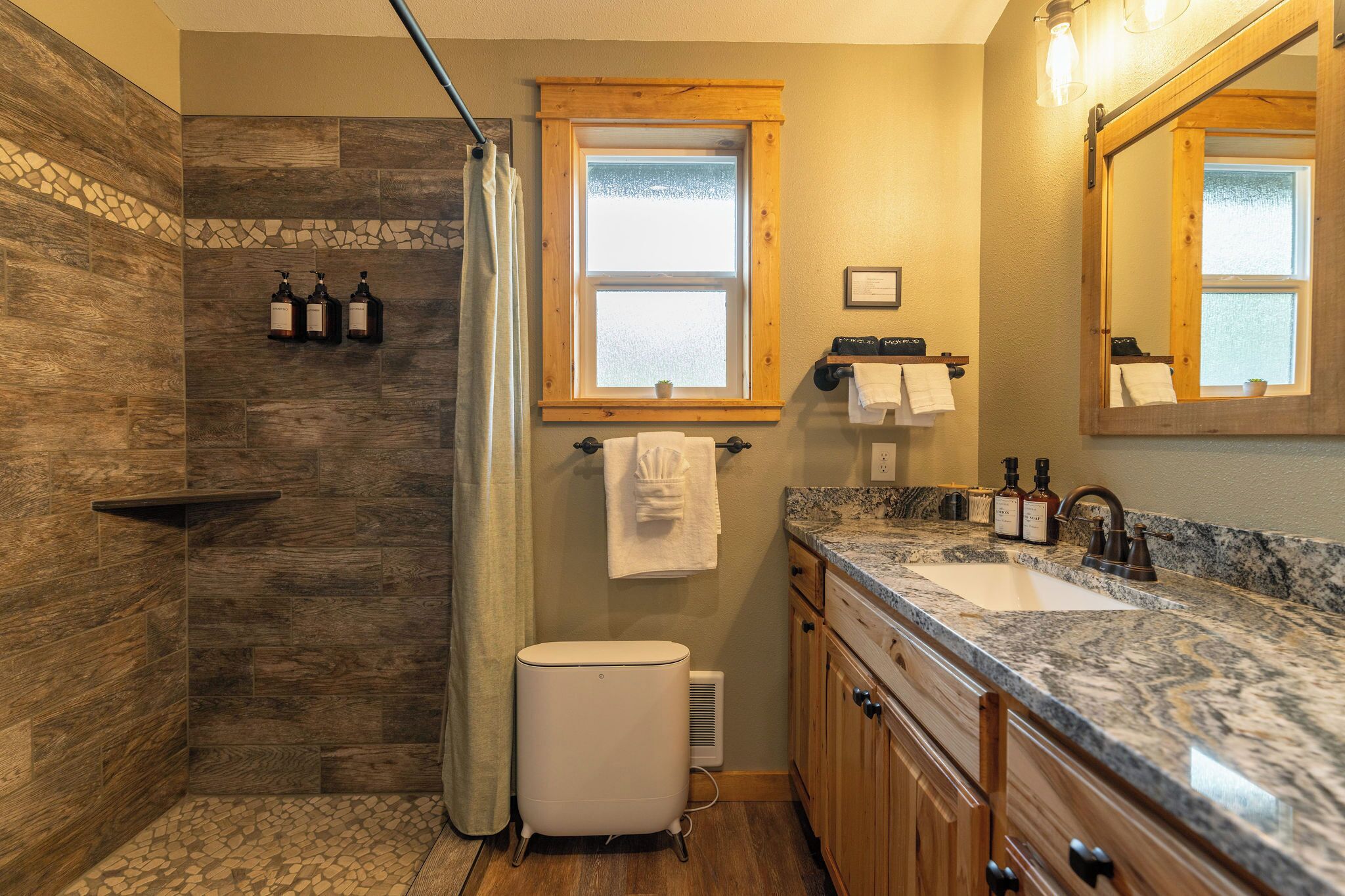 Une salle de bain avec une douche, un lavabo et un meuble-lavabo.